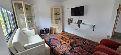 a living room with a white couch and a tv at El Encanto - El Peñol in Chiquinquirá