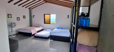 a room with two beds and a fan in it at Apartamento en Santa Fe de Antioquia con jacuzzi in Santa Fe de Antioquia