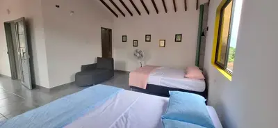 a room with two beds and a fan in it at Apartamento en Santa Fe de Antioquia con jacuzzi in Santa Fe de Antioquia