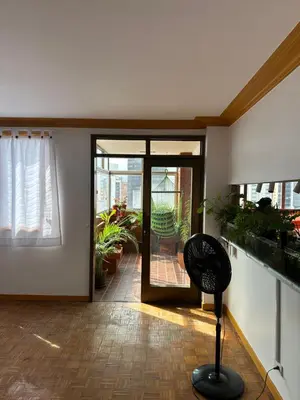 a living room with a glass door and a chair at As Seen On Netflix NARCO house in Medellín