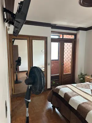 a room with a fan in the middle of a bedroom at As Seen On Netflix NARCO house in Medellín