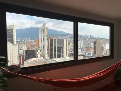 a hammock in a window with a view of a city at As Seen On Netflix NARCO house in Medellín