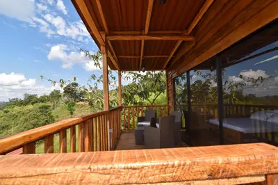 a wooden deck with a table and chairs on it at Cabañas naturales cerca a la hacienda Nápoles in Doradal