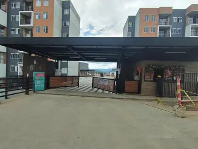 a building with a gate in a parking lot at Confortable Apartamento cerca Aerop JMC in Rionegro