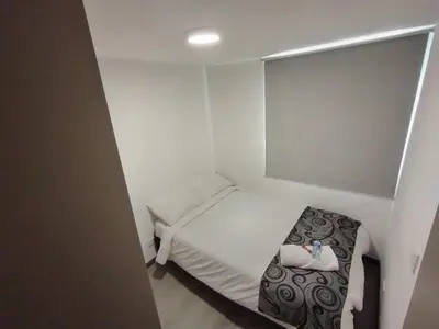 a small room with a bed and a chair in it at Confortable Apartamento cerca Aerop JMC in Rionegro
