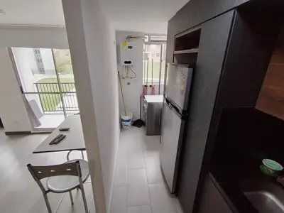 a small kitchen with a table and a refrigerator at Confortable Apartamento cerca Aerop JMC in Rionegro