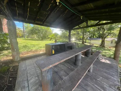 a wooden bench sitting under a pavilion with a grill at Finca Doradal descanso, vacaciones or teletrabajo in Doradal