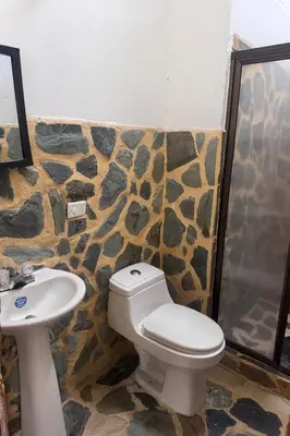 a bathroom with a toilet and a sink at Finca Doradal descanso, vacaciones or teletrabajo in Doradal