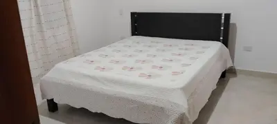 a bed with a white blanket with pink flowers on it at La Isabella - Descanso & Naturaleza in Estación El Salto
