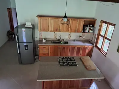 a kitchen with a refrigerator and a counter top at La Isabella - Descanso & Naturaleza in Estación El Salto