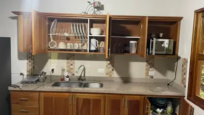 a kitchen with wooden cabinets and a sink at La Isabella - Descanso & Naturaleza in Estación El Salto