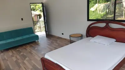 a bedroom with a bed and a couch at Finca Hotel Rancho Cattleya in Chinchiná