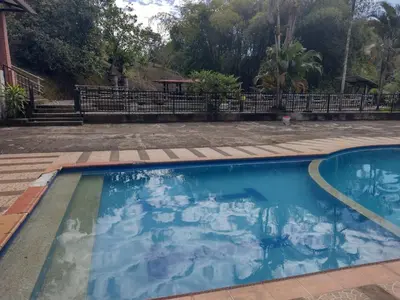 a swimming pool with blue water in a yard at Finca Hotel Rancho Cattleya in Chinchiná