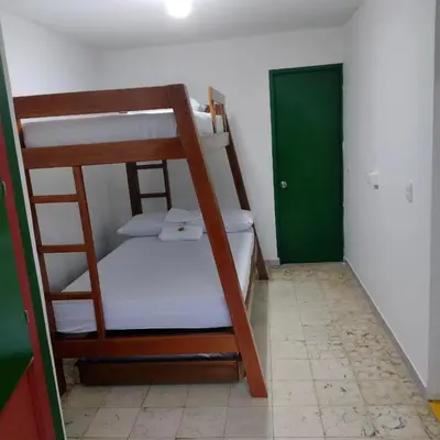 a room with two bunk beds and a green door at Finca Hotel Rancho Cattleya in Chinchiná