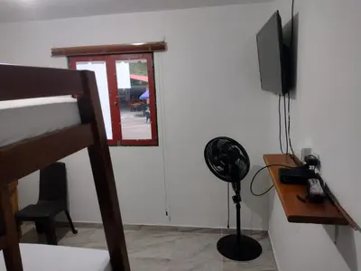 a room with a fan and a television and a desk at Finca Hotel Rancho Cattleya in Chinchiná