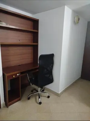 a desk with a black chair in a room at El mejor sector del Poblado para estancia mínima de 1 mes in Medellín
