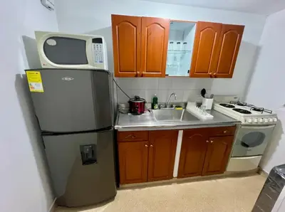 a small kitchen with a refrigerator and a sink at El mejor sector del Poblado para estancia mínima de 1 mes in Medellín