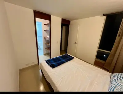 a bedroom with a bed with a blue pillow on it at El mejor sector del Poblado para estancia mínima de 1 mes in Medellín