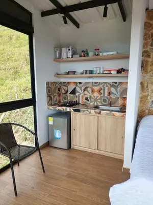 a room with a kitchen with wooden cabinets and a window at Cabaña Refugio Amani in Norcasia