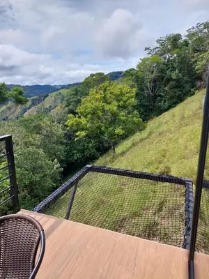 a balcony with a table and a view of a valley at Cabaña Refugio Amani in Norcasia