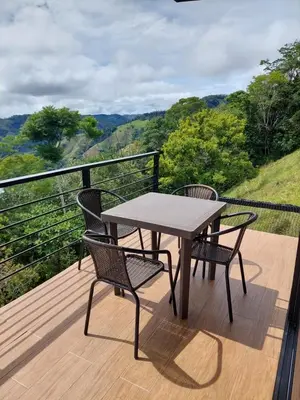a table and chairs on a deck with a view at Cabaña Refugio Amani in Norcasia