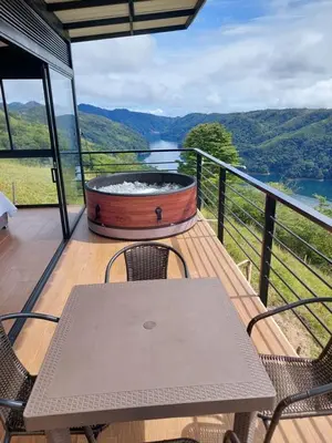 a table and chairs on a balcony with a hot tub at Cabaña Refugio Amani in Norcasia