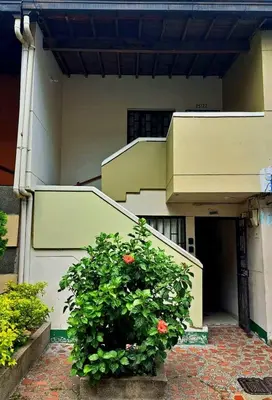a building with a staircase and a flower bush at Habitación central con cama doble #1 in Medellín