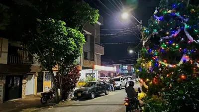 a christmas tree on a city street at night at Habitación central con cama doble #1 in Medellín