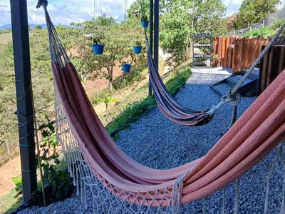 a couple of hammocks hanging from a fence at Cabaña Martina in Marinilla