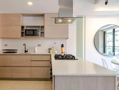 a kitchen with a white counter top and wooden cabinets at NOK Spectacular 3 BR w Balcony in Laureles Medellin in Medellín