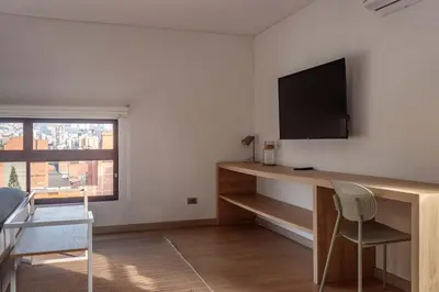 a living room with a desk with a television on a wall at NOK Stylish Studio w Balcony in Laureles Medellin in Medellín