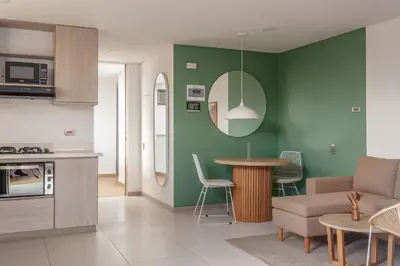 a kitchen and living room with green walls at NOK Stylish Studio w Balcony in Laureles Medellin in Medellín