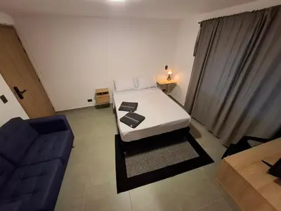 a small room with a bed and a couch at Hotel La Casona Estadio in Medellín
