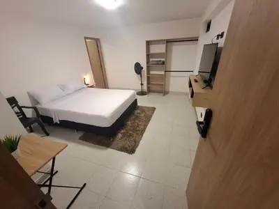 a bedroom with a bed and a television in it at Hotel La Casona Estadio in Medellín