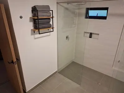 a bathroom with a shower and a glass door at Hotel La Casona Estadio in Medellín