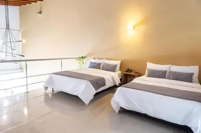 two beds sitting next to each other in a room at Hotel Laureles Loft in Medellín