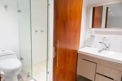 a bathroom with a toilet and a sink and a shower at Hotel Laureles Loft in Medellín