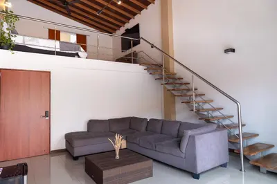 a living room with a couch and a staircase at Hotel Laureles Loft in Medellín