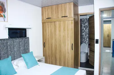 a bedroom with a bed and a wooden cabinet at Pura Vida in Quibdó