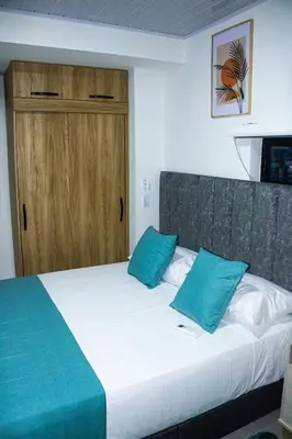 a bedroom with a bed with two blue pillows at Pura Vida in Quibdó