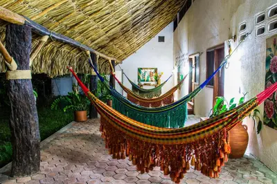 a hammock hanging from the side of a building at Hotel Brisas La Gaviota Mariquit-Tolima in Mariquita