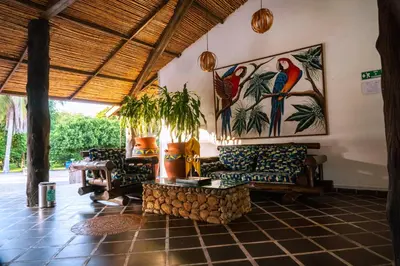 a living room with couches and a painting of birds at Hotel Brisas La Gaviota Mariquit-Tolima in Mariquita