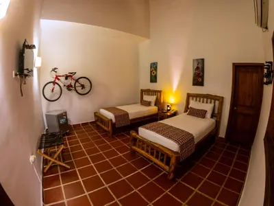 a room with two beds and a bike on the wall at Hotel Brisas La Gaviota Mariquit-Tolima in Mariquita