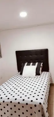 a bedroom with a bed with a black and white comforter at Rento apartamento por días in Manizales