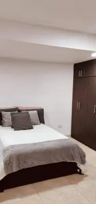 a bedroom with a large bed and wooden cabinets at Rento apartamento por días in Manizales