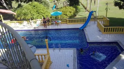 a pool at a resort with people playing in it at Villa Kelly Farm in San Jerónimo