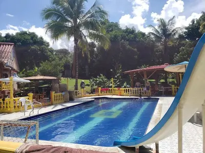 a swimming pool with a slide in a resort at Villa Kelly Farm in San Jerónimo