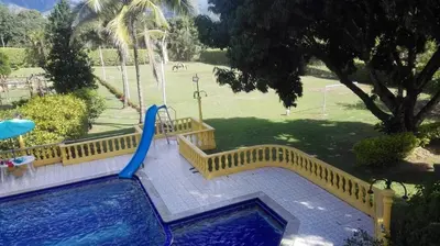 a playground with a slide and a pool with a water slide at Villa Kelly Farm in San Jerónimo