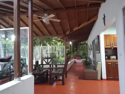 a living room with a ceiling fan and a table at Villa Kelly Farm in San Jerónimo