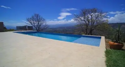 a swimming pool with a view of the mountains at Finca Mirador de Santágueda in Palestina